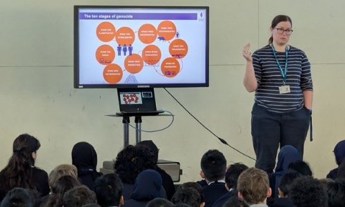 Teacher presenting the Holocaust Memorial Assembly in front of Year 7 students